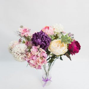 small bunch of purple, pink and voilet flowers in a vase, seen from the top